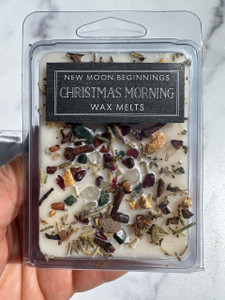 Christmas Morning Wax Melts in clear clamshell package with New Moon Beginnings label, topped with garnet, bloodstone and clear quartz crystal chips and herbs