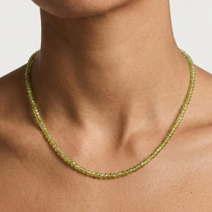 Faceted peridot beaded necklace worn close-up on the collarbone