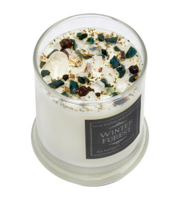Winter Forest Candle in a glass jar topped with Bloodstone, Clear Quartz, berries, and dried herbs
