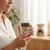 Woman holding Positive Energy Wax Melts in a bright room with a ceramic wax warmer in the background