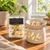 Positive Energy Wax Melts package beside a ceramic wax warmer melting a crystal and herb topped wax cube on a sunny wooden table