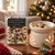 Christmas Morning Wax Melts clamshell beside a glowing white ceramic wax warmer with melted wax and crystal chips, set by a Christmas tree with ornaments and lights