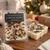 Christmas Morning Wax Melts package next to an unwrapped six cube wax melt bar topped with crystal chips and herbs on a wooden table with a Christmas tree behind