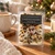 Christmas Morning Wax Melts package on a wooden table beside a speckled coffee mug, knit blanket and pine branches for a cozy holiday morning