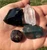 Close up of the Raw Yule Crystal Set in hand showing the red flecks in the Bloodstone and the Garnet crystal faces