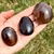 Three dark Smoky Quartz Palm Stones in hand, polished ovals in deep chocolate brown