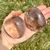 Two light Smoky Quartz Palm Stones in hand with translucent tan color and natural inclusions