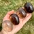 Four Smoky Quartz Palm Stones lined up in hand from light translucent to near black