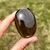 Dark Smoky Quartz Palm Stone held in hand showing its glossy polished surface