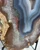 Close-up of the slab's raw tan rind, orange agate bands and radiating white quartz fans