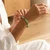 Woman in a linen top fastening a Variscite beaded bracelet on her wrist