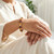 Woman wearing a Mookaite elastic bracelet on her wrist with a cream linen top