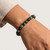 Seraphinite beaded bracelet worn on a wrist against a plain neutral background