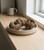 Two dried Rose of Jericho plants in a shallow ceramic dish on a windowsill