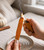 Lighting the tip of a Pumpkin Spice dipped Palo Santo stick over a ceramic dish