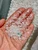 Clear quartz crystal chips spread across an open hand showing the 3mm to 5mm size range