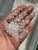 Loose clear quartz chips sparkling in sunlight in an open palm