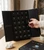 Hand opening drawer 12 of the crystal advent calendar on a table beside a raw crystal cluster and the box lid