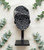 Black Amethyst cluster on its iron stand laid flat on linen surrounded by eucalyptus sprigs