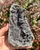 Raw Black Amethyst geode with deep botryoidal druzy formations in smoky gray and violet tones, held in hand