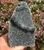 Raw Black Amethyst geode with a layered druzy crystal ledge and natural rough edges, held outdoors