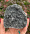 Black Amethyst geode from Uruguay held in hand, showing sparkling dark gray drusy quartz crystals
