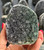 Close-up of a Black Amethyst geode with glittering charcoal drusy crystals, held in hand