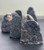 Group of Black Amethyst geodes standing upright on a dark surface, showing their polished bases and drusy crystal faces