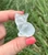 Clear Quartz sitting cat figurine held in hand, showing its rounded body and tucked paws
