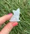 Clear Quartz sitting cat carving with pointed ears and carved whisker details, held in hand