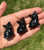 Hand holding three Smoky Quartz sitting cat carvings with glossy dark smoky finish