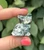 Front view of a Tree Agate sitting cat with carved face, showing white stone with green branching patterns
