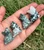 Five Tree Agate sitting cats in an open hand, each with its own mix of white and green