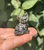 Close-up of a Pyrite sitting cat showing its carved eyes and metallic gold and black finish