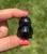 Side profile of a dark Smoky Quartz owl held between fingers outdoors