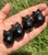 Four polished Smoky Quartz owls lined up in an open hand