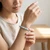 Woman wearing a Larimar chip bracelet, seated at a wooden table