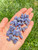 Small Tanzanite Tumbled Stones Grade A in an open hand, pale lavender-blue polished pieces