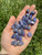 Polished Tanzanite Tumbled Stones in an open palm, violet-blue stones with lighter cloudy zones