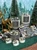 Winter Forest candle collection in glass jars, a silver tin, and tealights, styled with gold reindeer and frosted mini pine trees