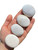 Four white Scolecite palm stones of varying sizes resting in an open hand