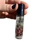 Close up of the New Moon Oil Roller held by the cap showing the crystal chips and herbs inside the bottle
