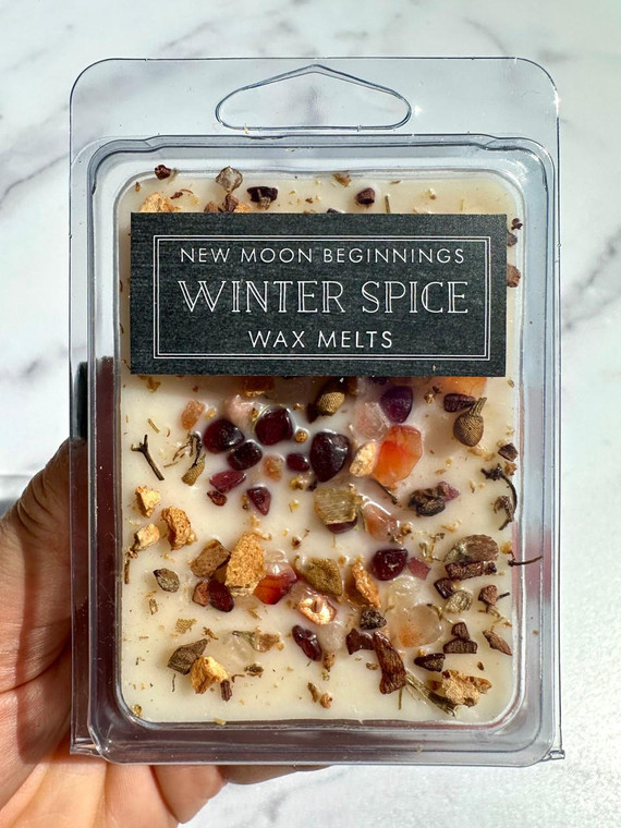 Winter Spice Wax Melts by New Moon Beginnings in a clear clamshell, cream soy wax topped with Garnet, Carnelian, Sunstone and Citrine chips with dried orange, chamomile and clove