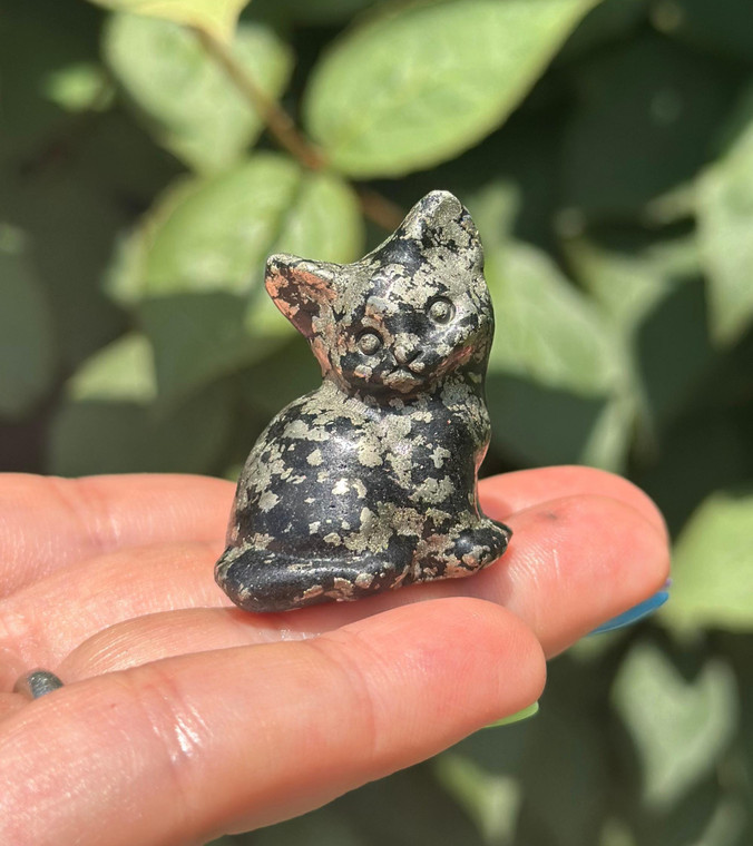 Polished Pyrite sitting cat carving from Africa held on fingertips, black matrix with metallic gold flecks