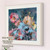 Put the Moment on Hold is a dreamy impressionistic floral figure painting by Shakia Harris featuring a woman in a flowing blue dress seated inside a large pink flower against a serene blue background. Soft brushwork and layered textures blend the female figure with blooming petals, creating an ethereal atmosphere inspired by stillness, reflection, femininity, and emotional escape. This romantic contemporary artwork combines abstract floral elements with figurative painting, offering calming blue and pink tones ideal for luxury interiors, bedrooms, living rooms, and elegant feminine spaces. The painting evokes peace, slow living, quiet beauty, and the feeling of pausing time to savor the present moment.