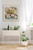 Elegant floral canvas wall art by Shakia Harris featuring soft blush pink, cream, sage green, and golden florals against a serene blue background. This impressionistic floral canvas print is displayed in a modern neutral interior and highlights premium features including water-resistant protection, fade-resistant archival inks, and a textured canvas finish. Romantic and airy in style, this oversized floral artwork brings warmth, softness, and sophisticated color into living rooms, bedrooms, dining rooms, and modern organic interiors. Designed to create a calming atmosphere while offering the elevated look of original fine art.