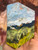 Shop I See Trees of Green, a 4x4 original textured oil landscape by Shakia Harris featuring rolling green fields, distant hills, and a luminous blue sky.