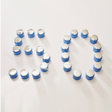 Number '50' formed by arrangement of blue and silver Phytomer product jars on white background