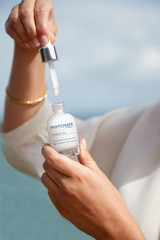 A woman holding the Pigment 2d high correction dark spot serum