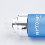 Chrome pump dispenser cap of the blue Emergence Even Skin Tone Refining Serum bottle against a white background.